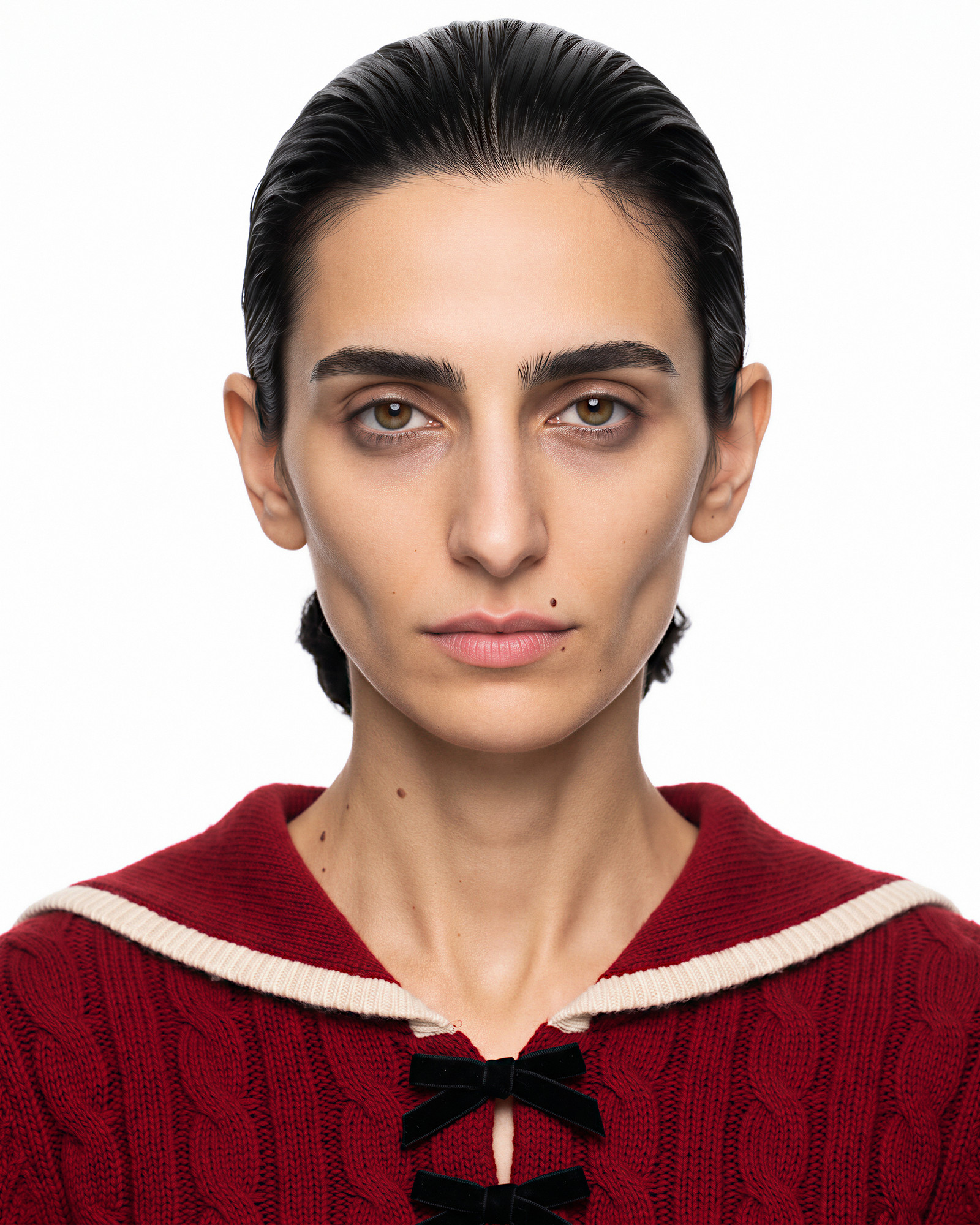 The reference — a character rendered from a written specification with no photograph: black hair combed back, a mole above the lip, a red cable-knit cardigan with a sailor collar and two black bows