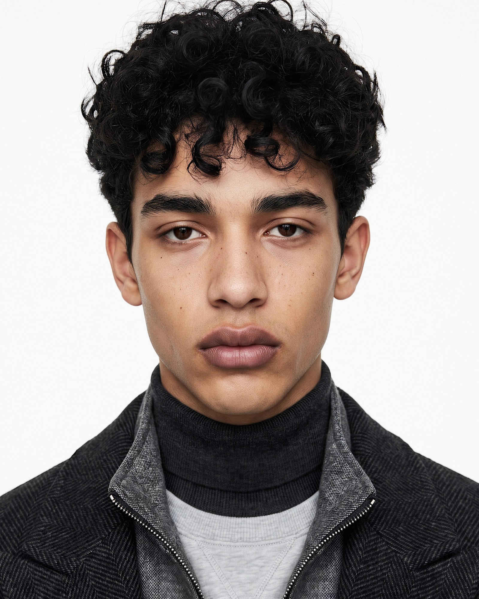 Portrait 2 restored — a darker-skinned face, curly black hair, freckles, a herringbone coat